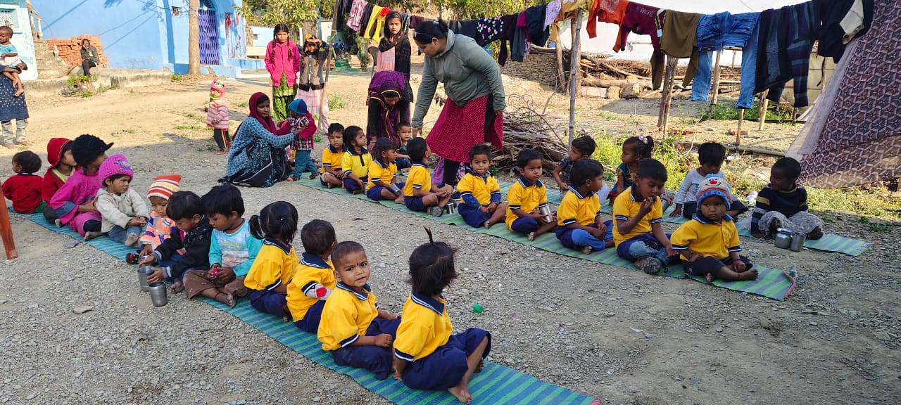 Anganwadi children sitting together in uniform